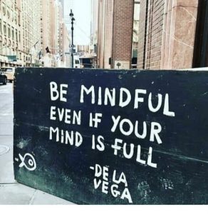Image of city wall that says "Be mindful even if your mind is full" -De La Vega